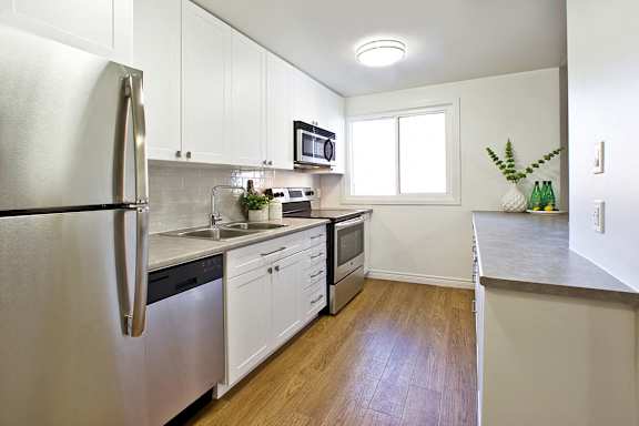 a kitchen with stainless steel appliances and white cabinets