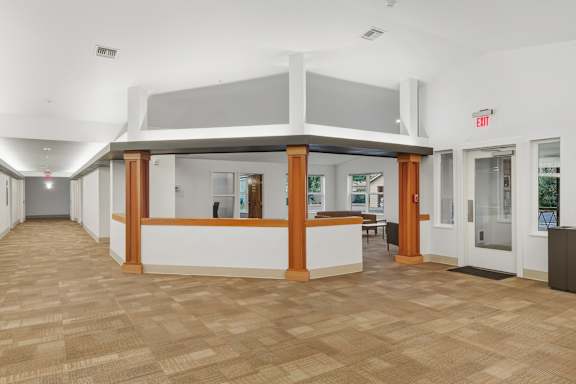 A reception area with a white counter and brown tiled floor.