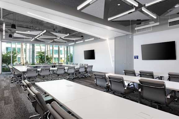 A conference room with a long table and chairs.