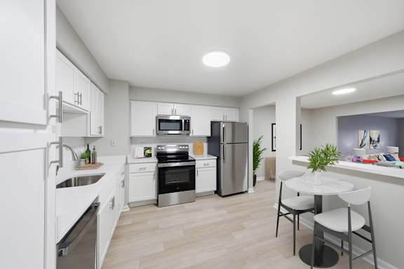 A modern kitchen with white cabinets and stainless steel appliances at Glens of Bloomfield Apartments, Bloomfield Hills, MI, 48301