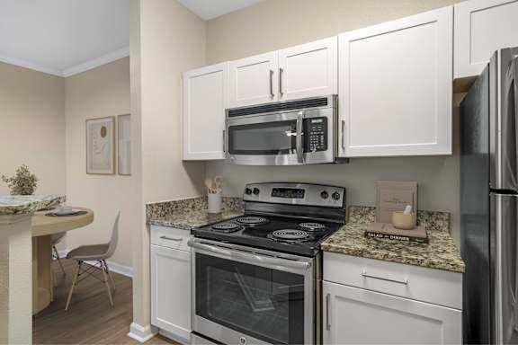 A kitchen with a stove, microwave, and refrigerator.