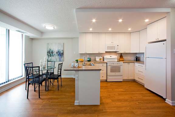 a kitchen with white cabinets and a table and chairs