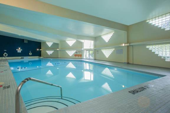 a swimming pool at a hotel with a blue water surface and white tiles