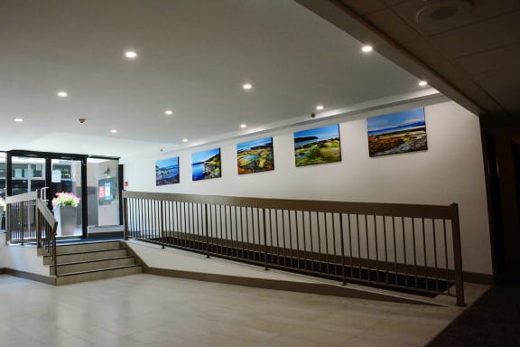 a view of a lobby with stairs and paintings on the wall