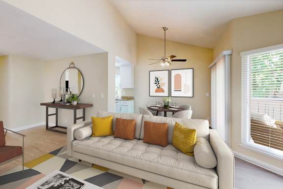 A living room with a white couch and a rug on the floor.