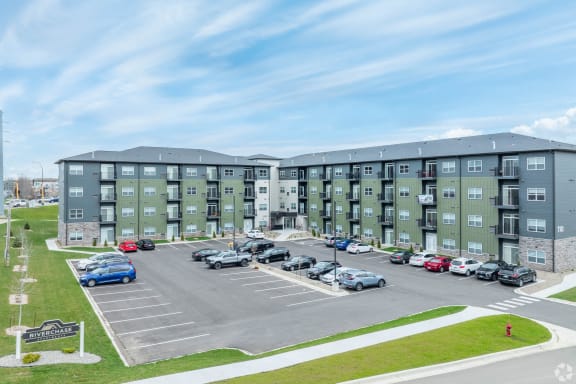 an exterior view of an apartment building with a parking lot