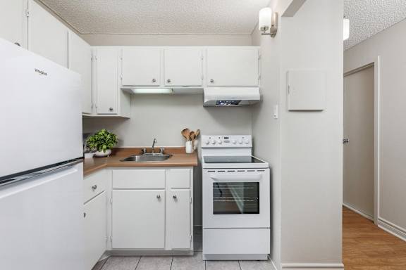 A small kitchen with white appliances and cabinets.