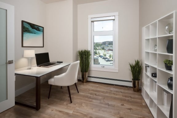 a home office with a window and a laptop on a desk