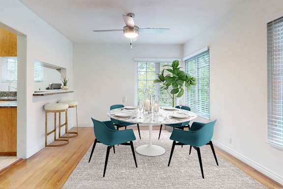 A dining room with a white table and blue chairs.