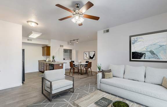 A modern living room with a white couch, a grey armchair, and a wooden coffee table.at Florentine Villas, Midvale, 84047