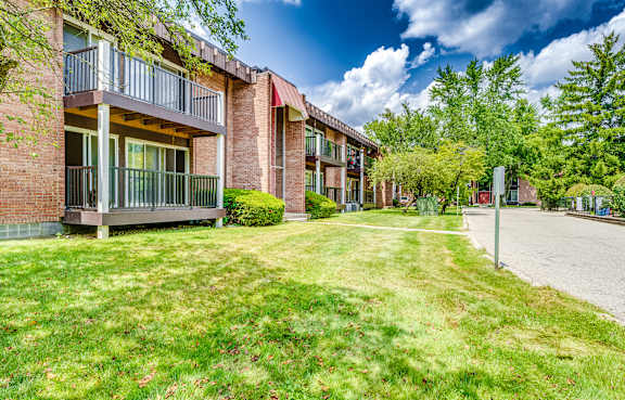 A row of apartment buildings with green lawns in front.