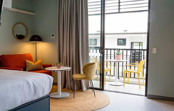 a living room with a green couch and a balcony