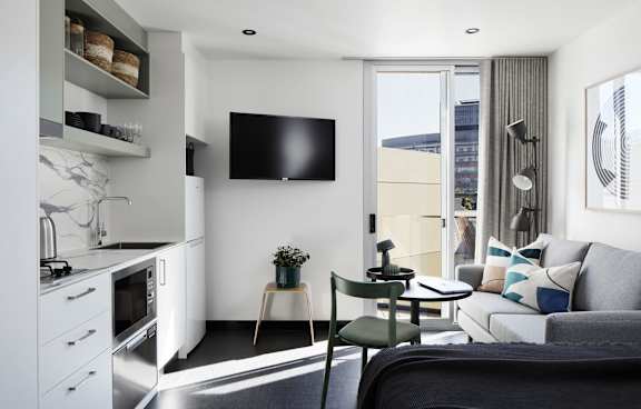 a living room with a green couch and a balcony