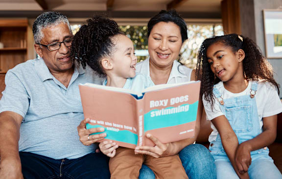 A family is reading a book together at Northside Hills Apartments, Griffin