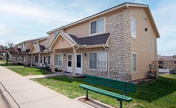A row of houses with a green bench in front of them.