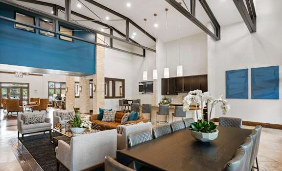 A modern dining room with a large table and chairs.