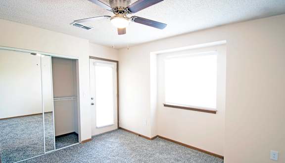 A room with a ceiling fan and a window.