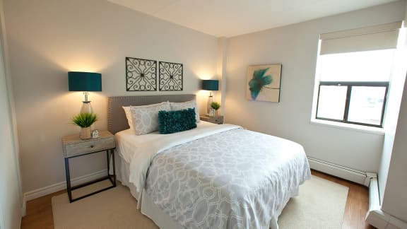 a bedroom with a white bed and a window