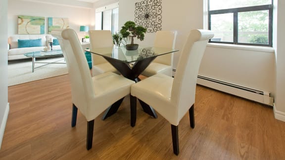 a dining room with a glass table and white chairs