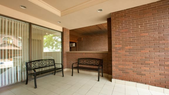 a porch with a bench and a brick wall
