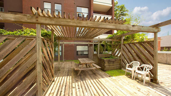 a deck with a picnic table and a wooden fence
