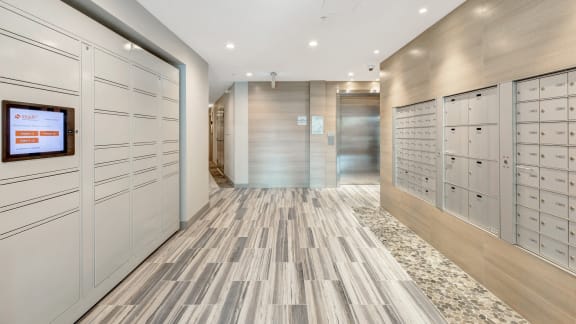 a long hallway with white lockers and wooden floors and a television in the center