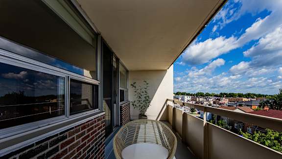 a balcony with a table and a chair and a view of a city