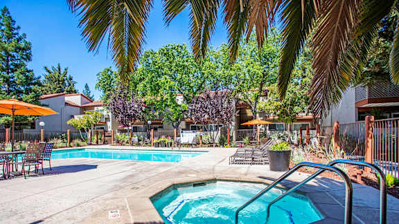 our apartments have a swimming pool and a patio with chairs and umbrellas at Valley Plaza Villages, Pleasanton, 94566