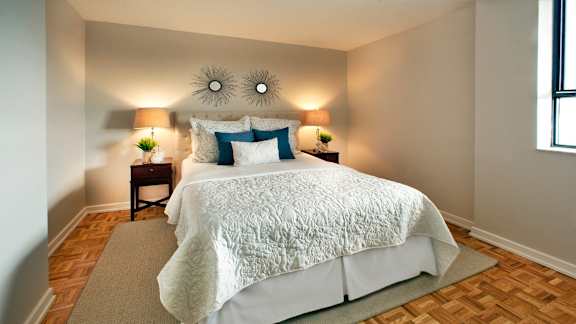 a bedroom with a bed and two mirrors on the wall