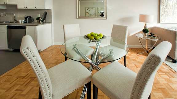a living room and dining room with a glass table and chairs