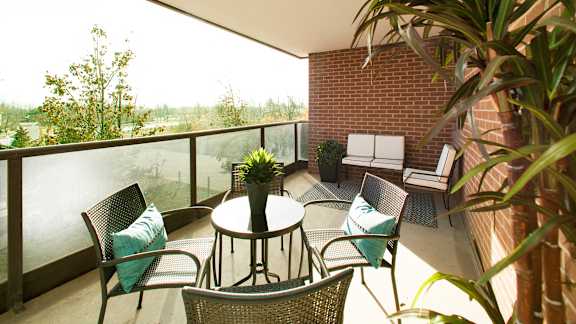a balcony with a table and chairs and a brick wall