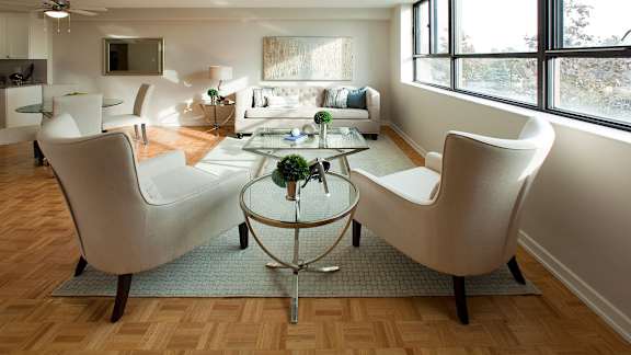 a living room with white chairs and a glass table