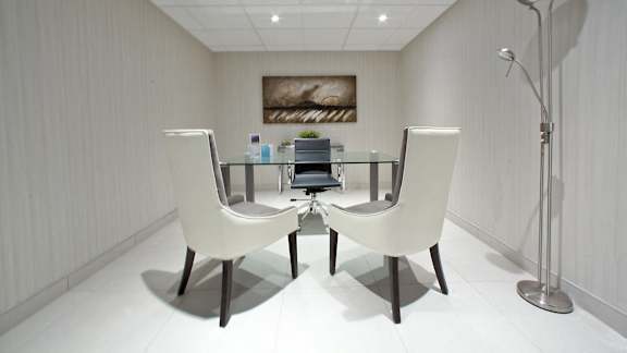 a conference room with white chairs and a glass table