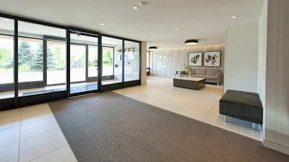a large living room with large windows and a rug