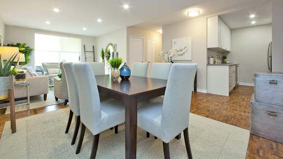 a dining room and living room with a table and chairs