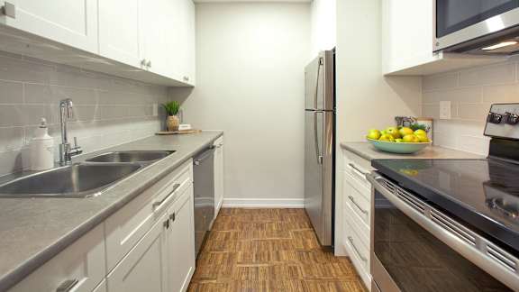 a kitchen with stainless steel appliances and white cabinets