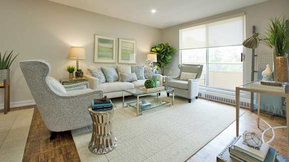 a living room with couches and chairs and a rug