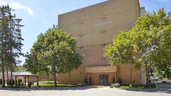 a brown building with trees in front of it
