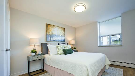 a bedroom with a large white bed and two windows