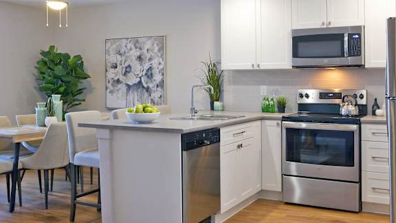 a kitchen and dining room with stainless steel appliances and a table