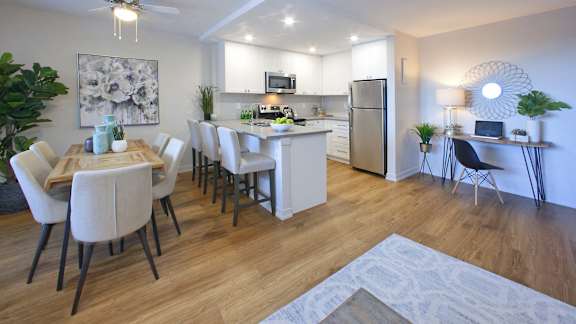 a living room and kitchen with a dining room table and chairs