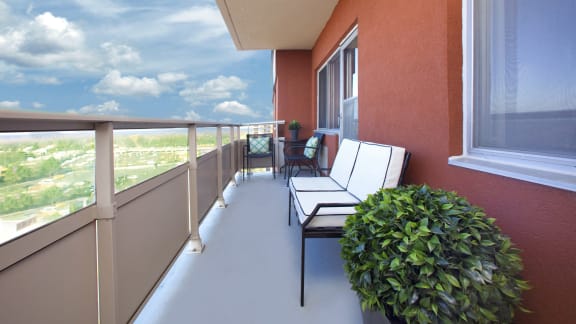 a balcony with a view of a city and a blue sky