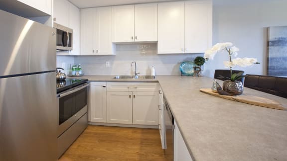 a kitchen with stainless steel appliances and white cabinets