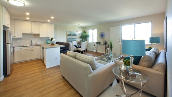 a living room and kitchen with couches and a table