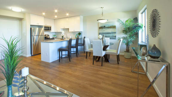 a dining room and kitchen area with a table and chairs