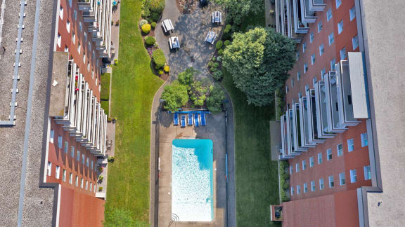 an aerial view of a swimming pool in the middle of some buildings