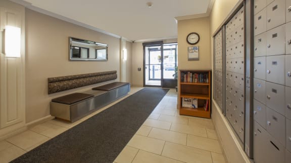 a hallway with lockers and benches and a clock on the wall