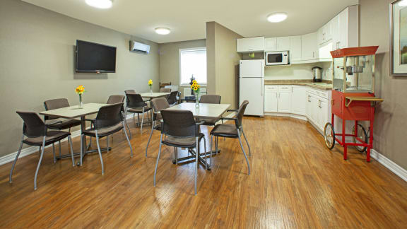 a dining room with tables and chairs and a kitchen with a red stove