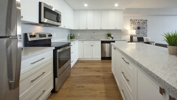 a kitchen with white cabinets and stainless steel appliances