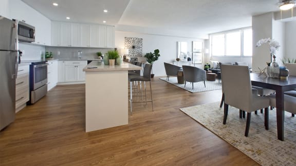 an open kitchen and living room with a dining room table and chairs